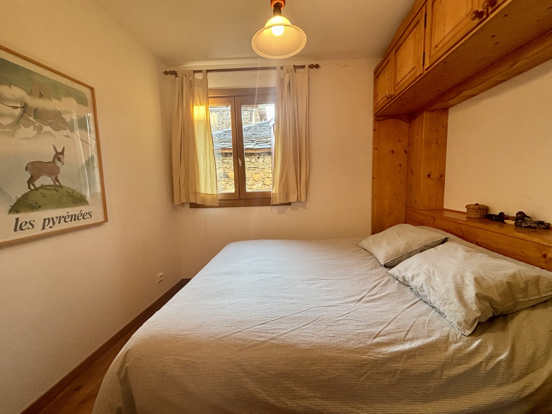 Cama matrimonial en una habitación cálida en frente de las montañas, de un apartamento vacacional en Cerler, pirineo aragones