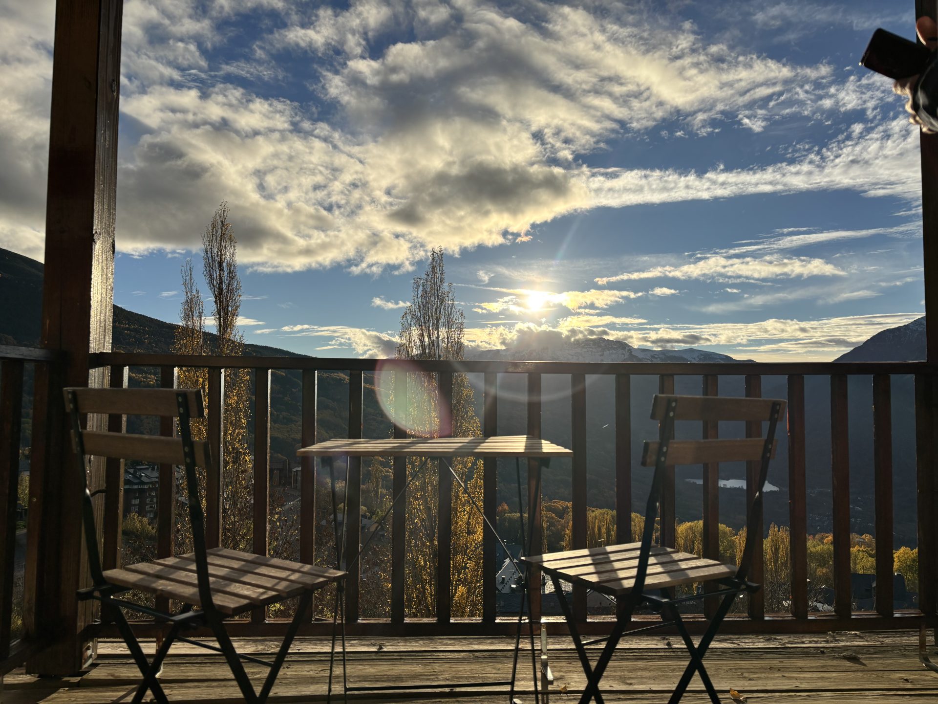 balcón de apartamento vacacional en el valle de benasque con mesa y sillas para disfrutar de las vistas a la montaña